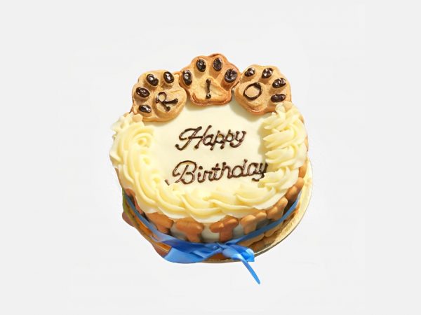 White round cake with creamy swirls and three paw-shaped cookie toppers.