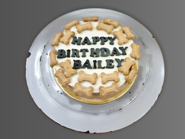 Round dog birthday cake topped with mini bone-shaped treats