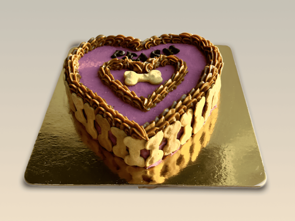 Heart-shaped dog cake with purple frosting and bone-shaped biscuits around the edges.